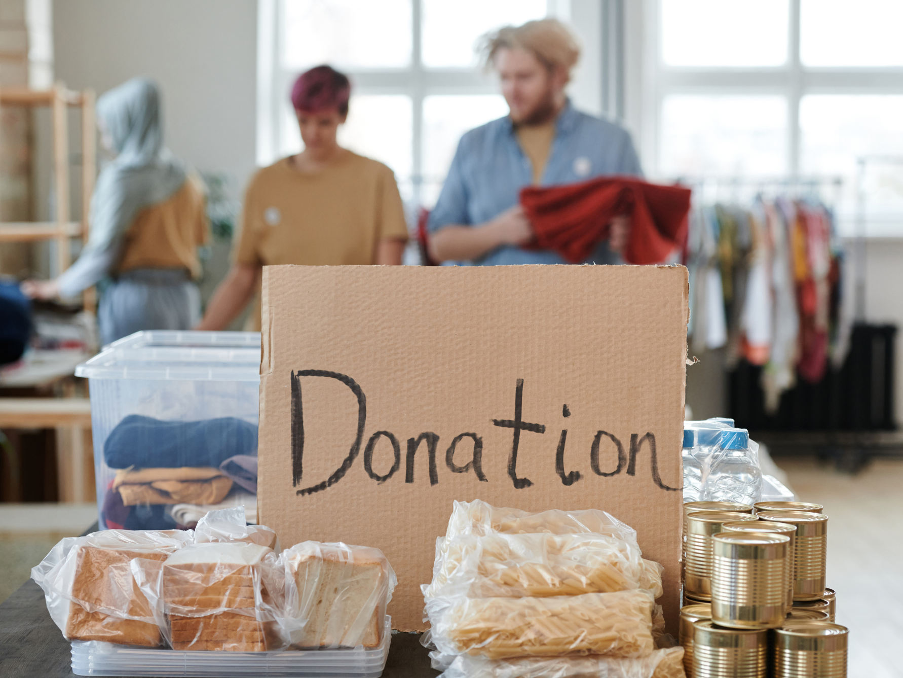 Donation image with people in background giving clothes away to charity